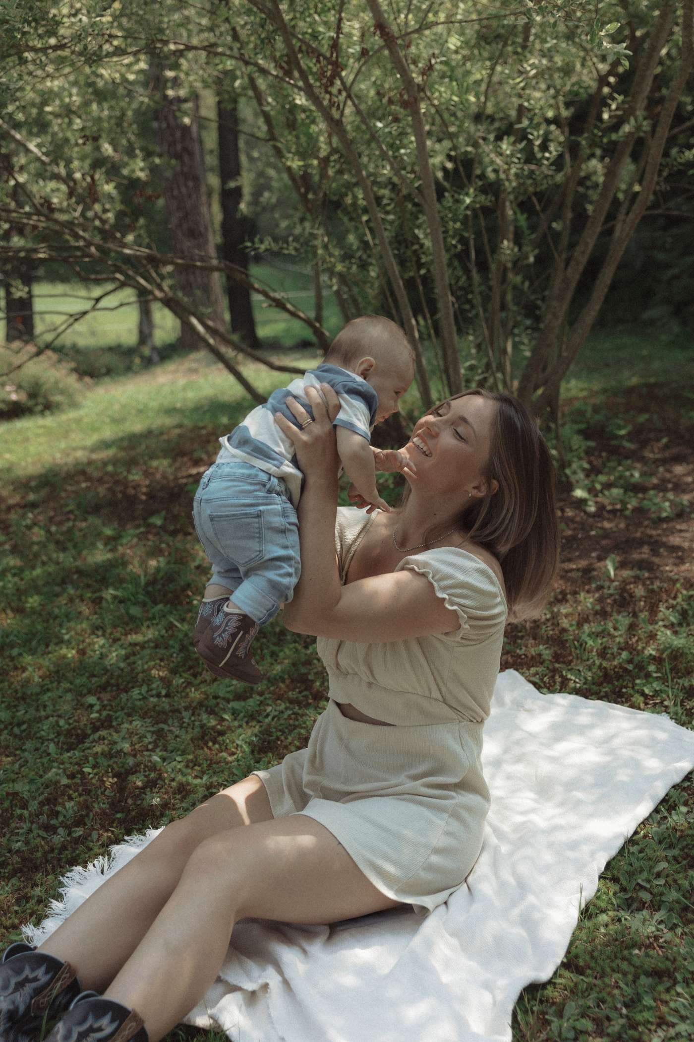 Anne-Sophie soulève son fils Hubert à bout de bras dans un parc
