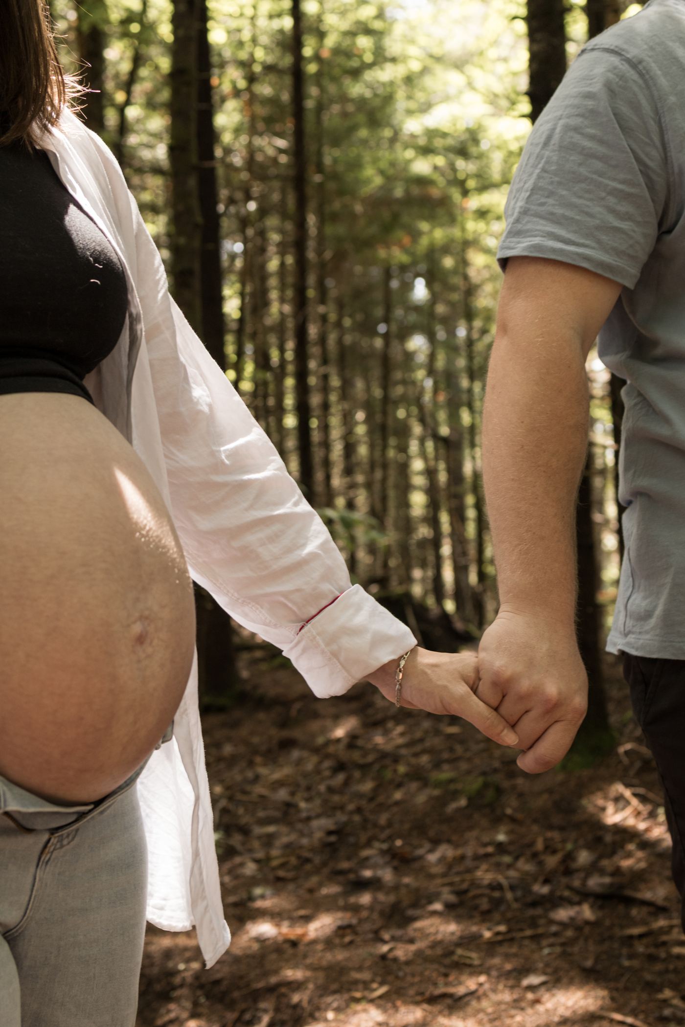 Couple en forêt, le ventre rond découvert et les mains liées