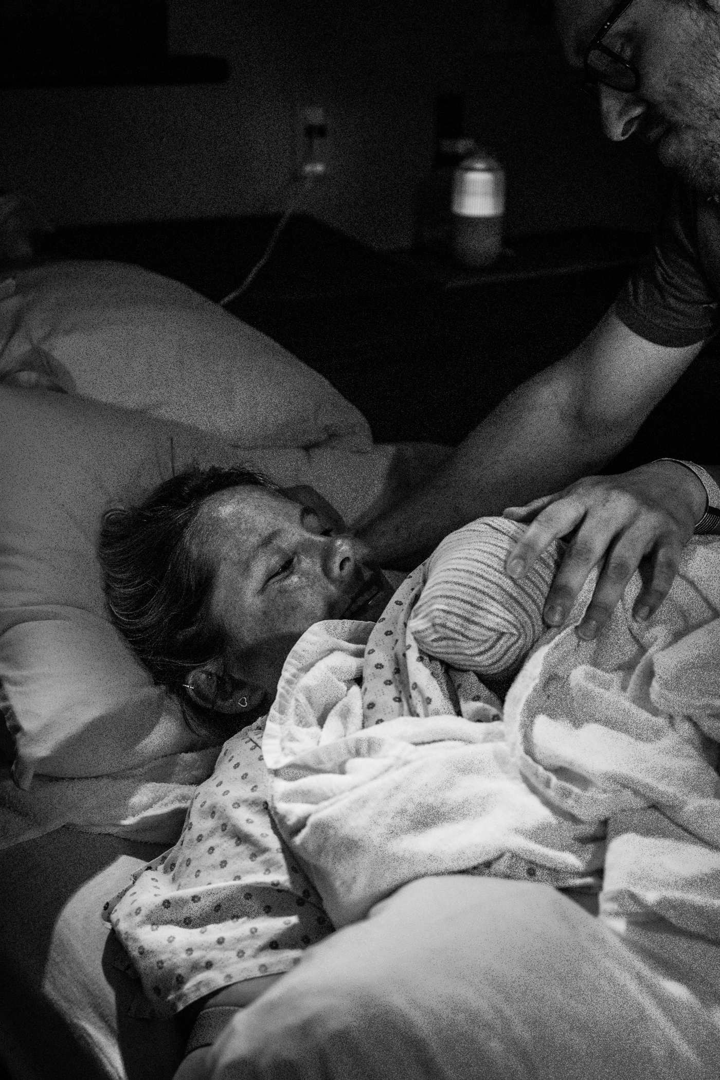 Une mère tient son nouveau-né contre elle juste après la naissance, en noir et blanc