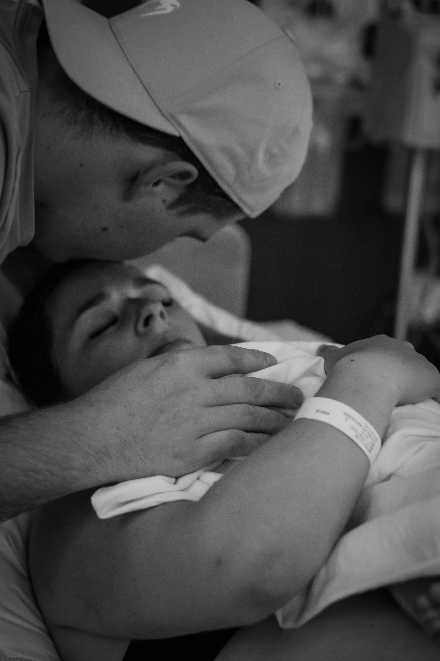 En noir et blanc, un père en peau à peau avec son nouveau-né